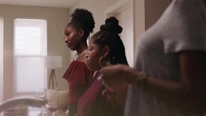The women listen as someone talks at the table