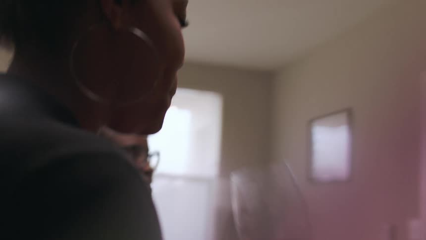 A woman takes a drink from a glass of wine