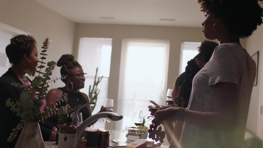 Women stand around a table talking