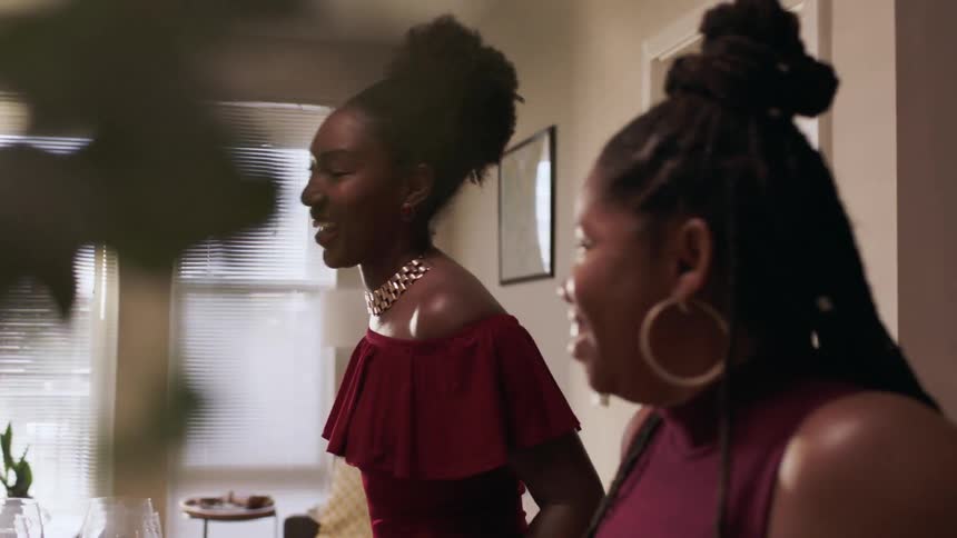 A family laugh and talk in the kitchen