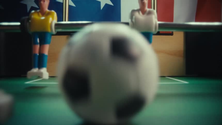 Closeup of a foosball ball scores a goal on a tabletop soccer game