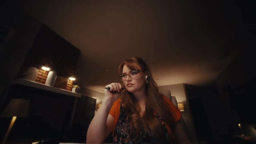 Woman typing on a calculator and working in front of a laptop
