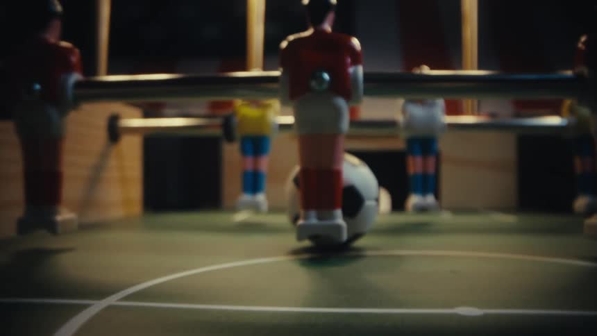 The table football game has soccer balls on it