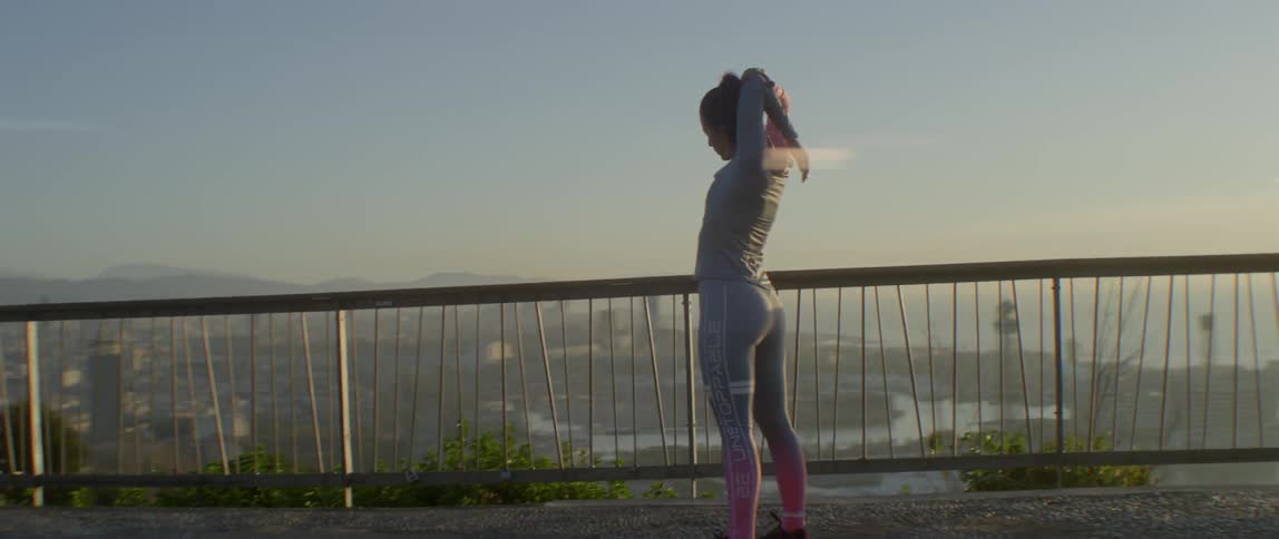 A woman stretches on a bridge