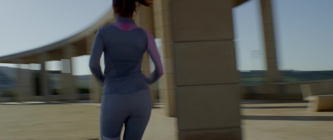 Woman runs through architectural posts