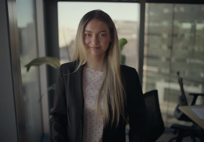 Woman in an office interacting with a smartphone
