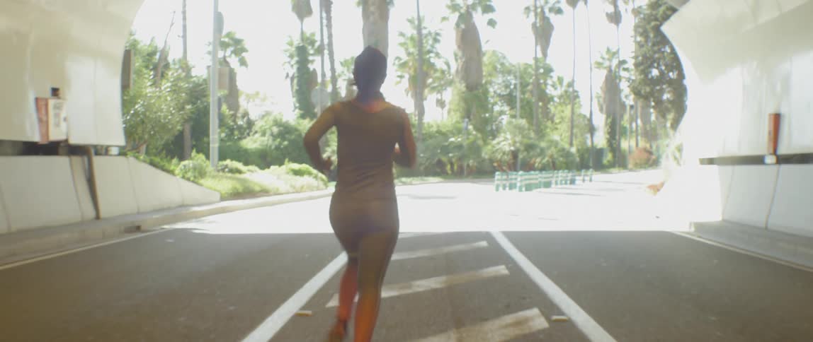 Woman jogging through a city tunnel