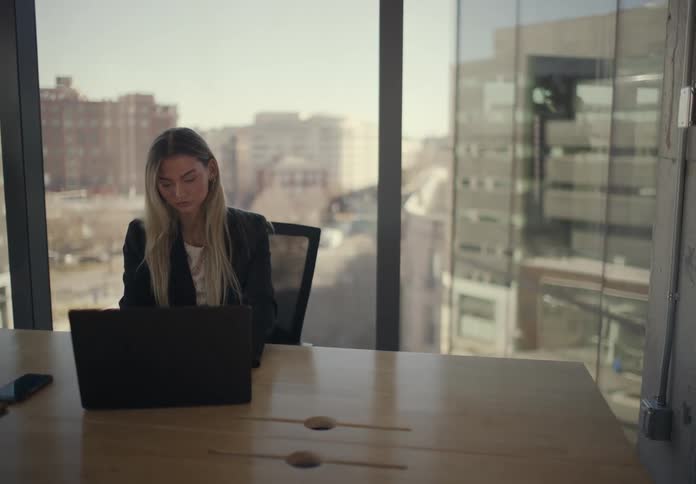 Woman working on a laptop in an office building