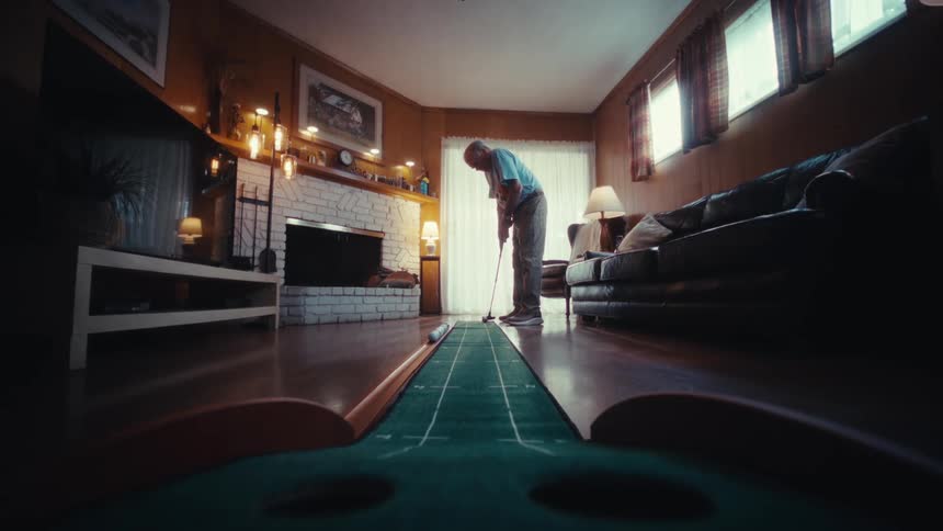 A man plays golf indoors