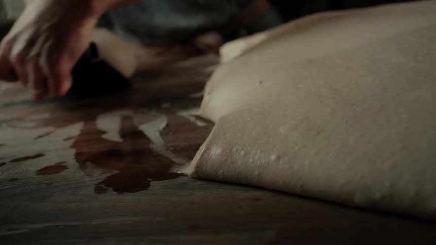 The cook is making balls of dough in the restaurant