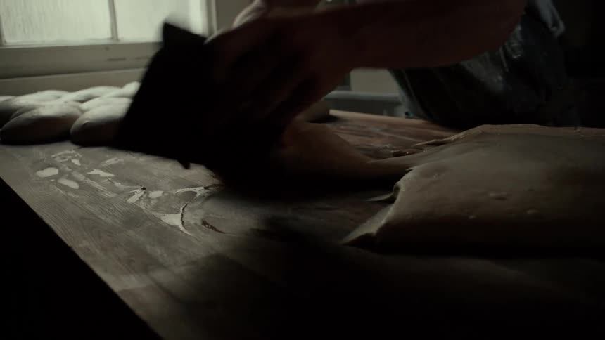 The cook is making balls of dough in his restaurant