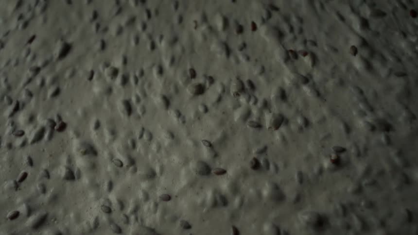A molded piece of dough slowly sliding across the surface it rests on