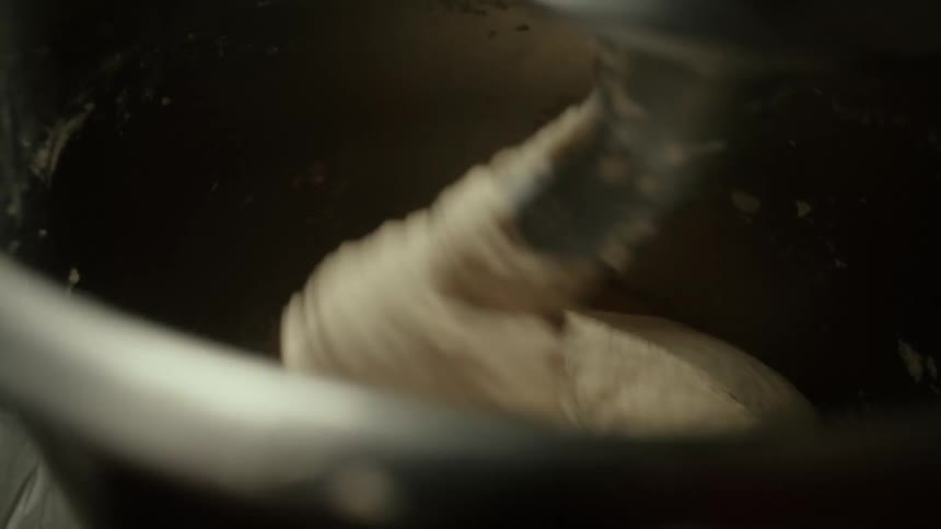 Dough being mixed inside a kitchen mixer at midday