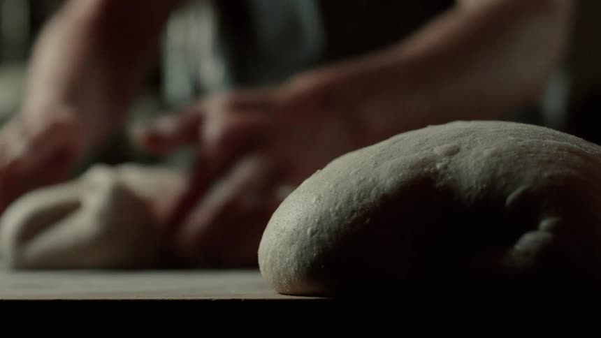 A person making loaves of bread