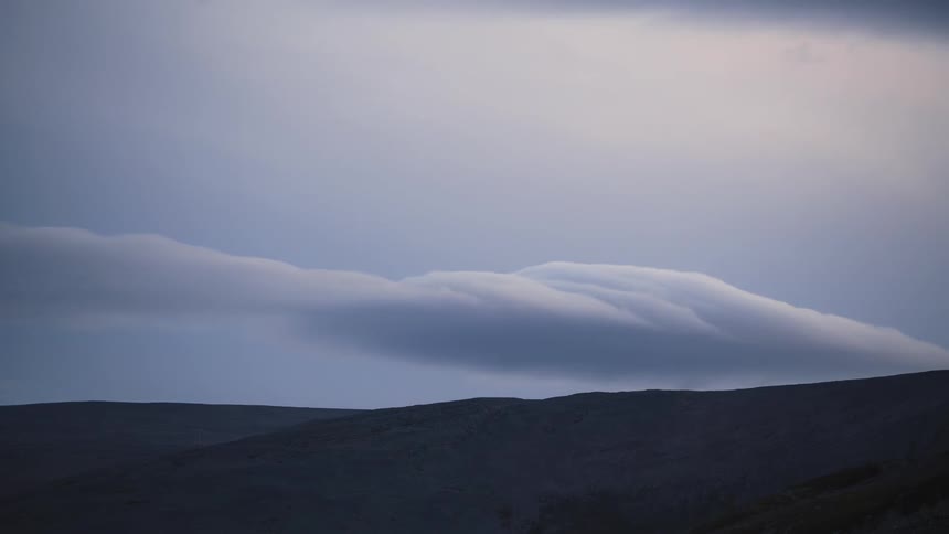 Clouds move over the sand dune