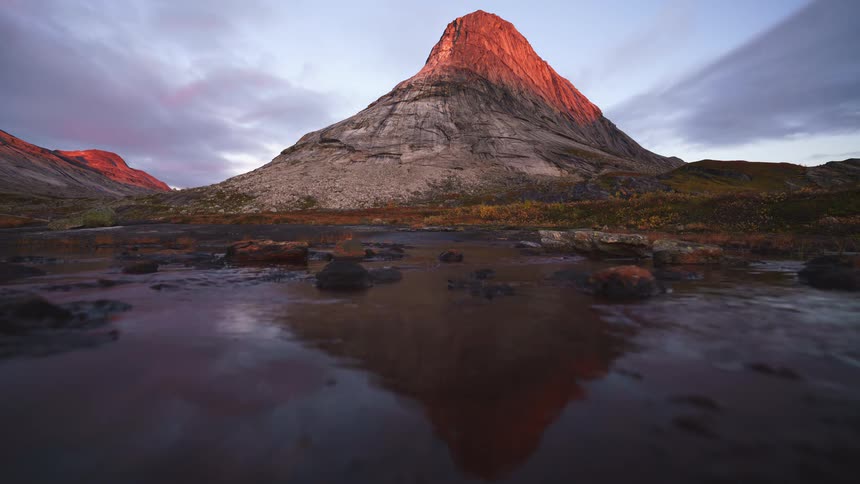 The lake water hits the bottom of the mountain