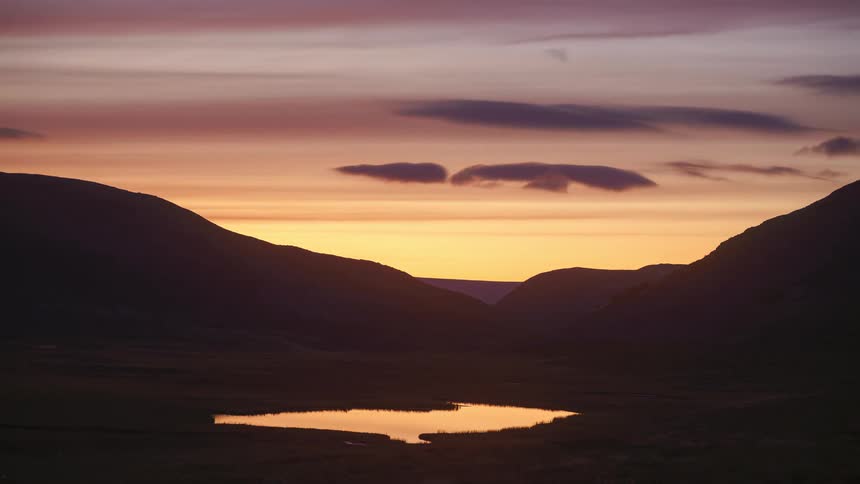 The sun slowly sets on the mountains