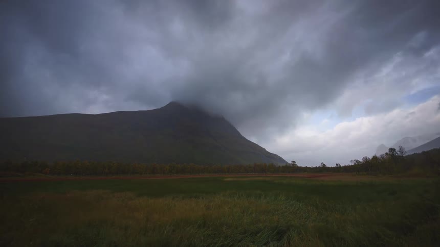 Heavy clouds flow over the windy field