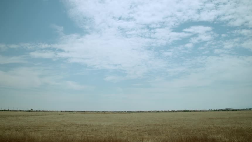 Clouds float over an open field
