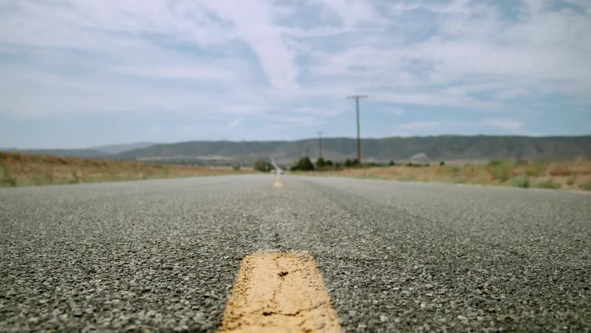 Power lines stand erect next to a desert road