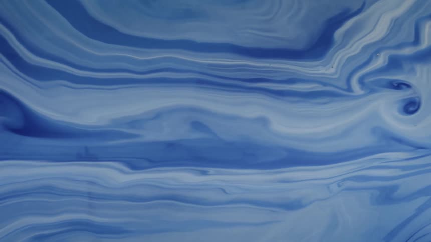 Blue and white liquids swirl together in a slow abstract fluid motion