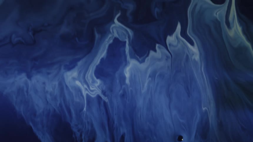 Blue and white fluids swirl and blend together in abstract patterns