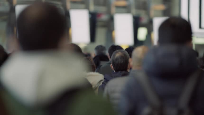 Pedestrians walk through an area lined with led screens