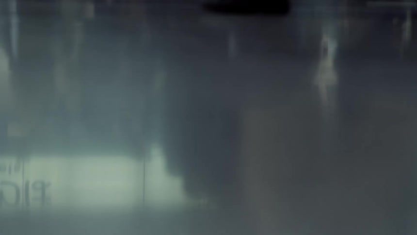 Human silhouettes appear blurred behind a translucent surface with diffused light