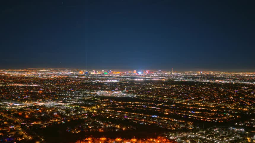 Aerial view of a sprawling city illuminated by countless lights beneath a dark night sky