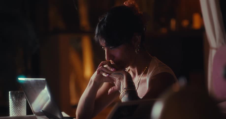 Woman sits at a table with a laptop computer