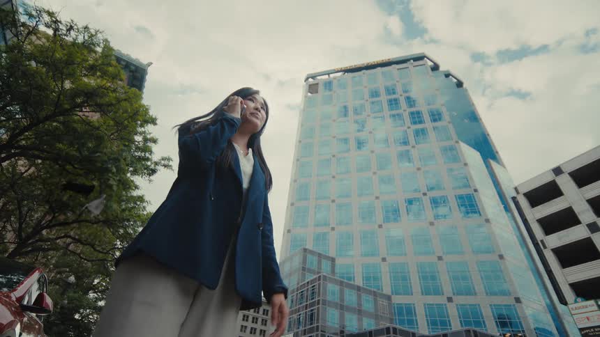 A woman talking on a phone while walking in a city