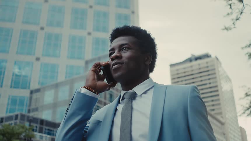 Man in a suit outdoors talking on a phone call