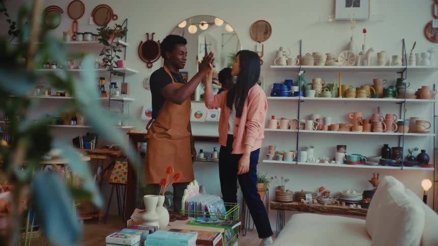 Two workers in the shop high five
