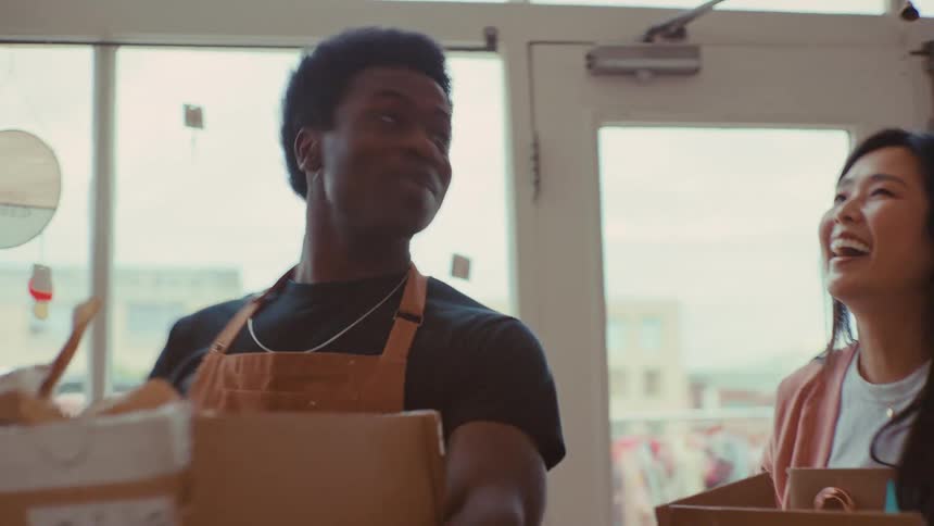 Two workers bring boxes into the store