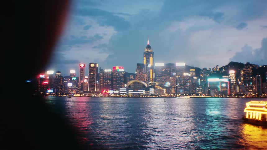 A woman taking photos of a city at dusk with a camera
