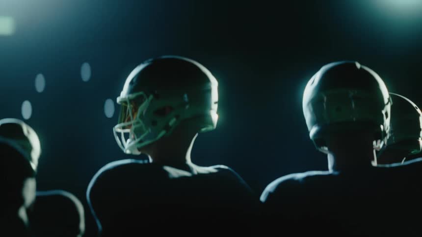 A group of football players standing in a stadium