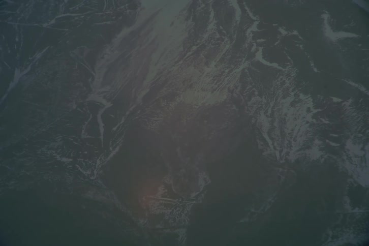 Snow on the rough terrain of a mountainside slope
