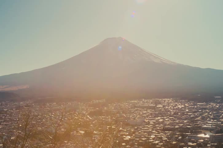 Urban view with mount fuji in the background lit by sunlight and city bathed in hazy glow