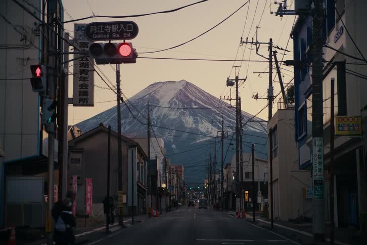 Japanese street scene with clear view of mount fuji in the background and red traffic light