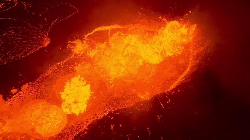 Molten lava erupts and churns in brilliant shades of orange and yellow against a dark volcanic backdrop with fiery splashes and glowing textures conveying intense heat raw power and the dramatic force of nature in motion