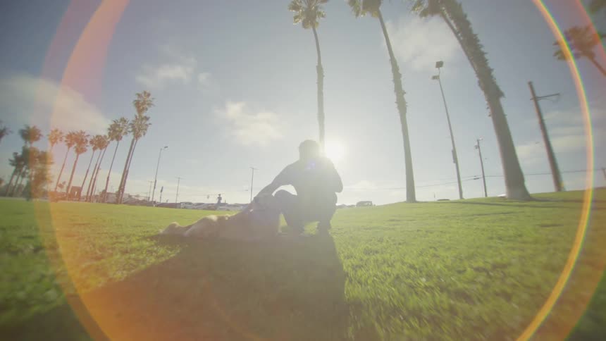 A man in a public park petting his golden retriever at sunset the warm light casting a soft glow as the dog leans into his touch