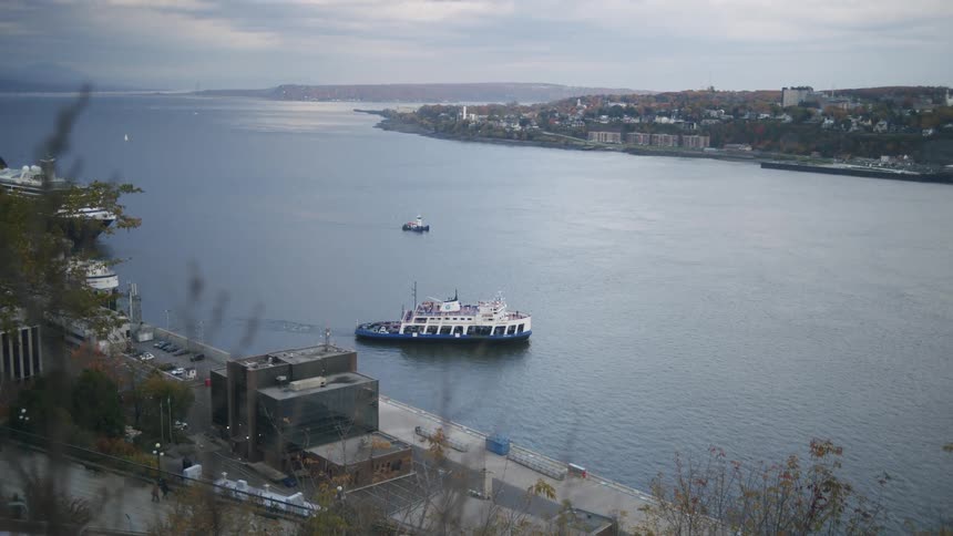 Boat moving across the sea with a coastal city in the background