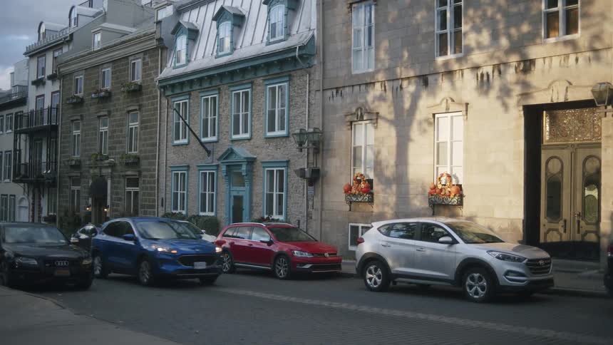 Cars parked and others in motion on an urban street