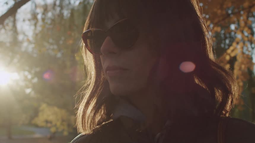 The woman looks at the trees in the forest