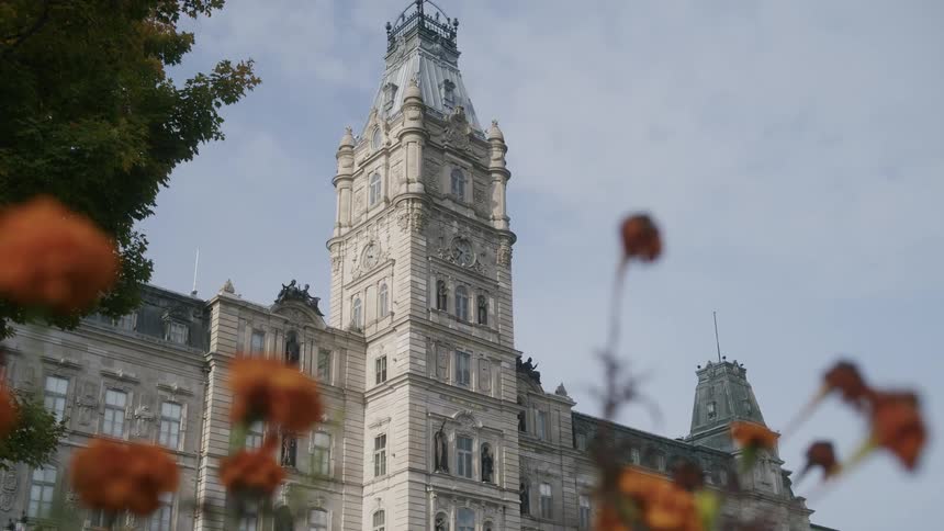 The tall stone building has arched windows