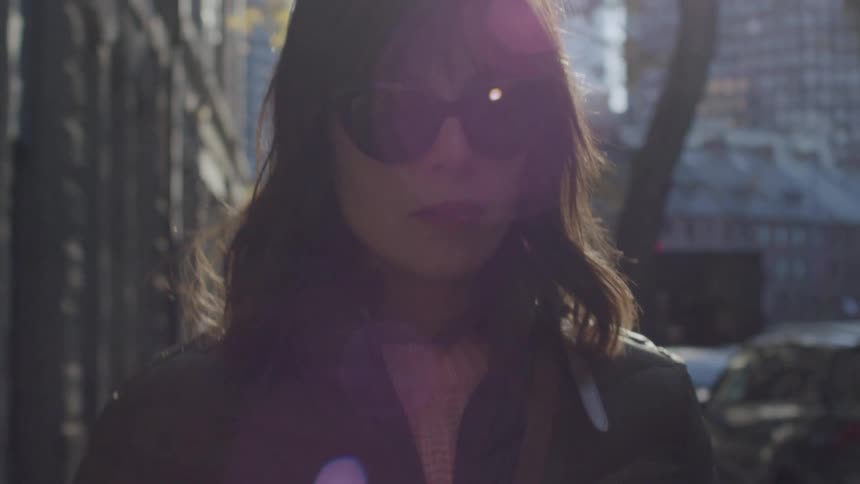 Woman wearing sunglasses walking through the city