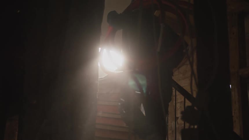 The construction worker carries supplies up the stairs