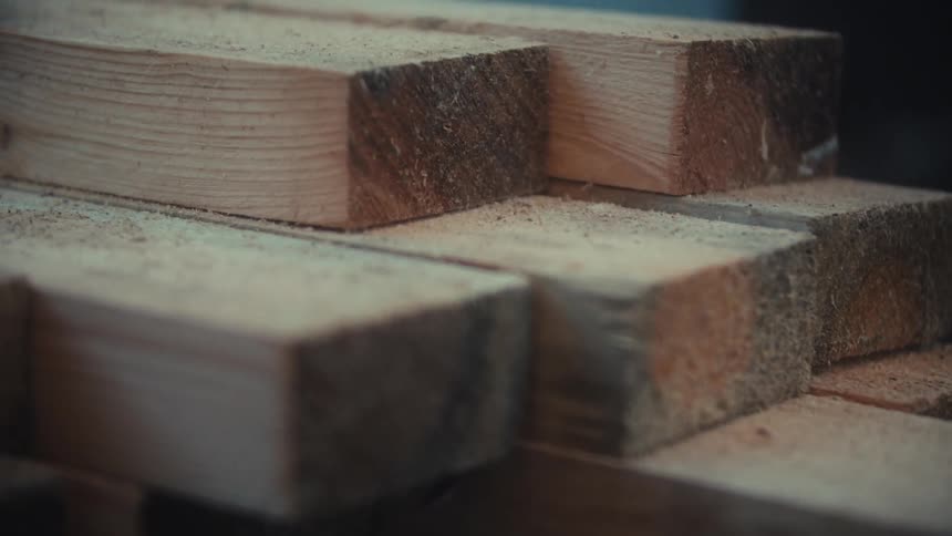 Stacked planks with visible sawdust and wood grain