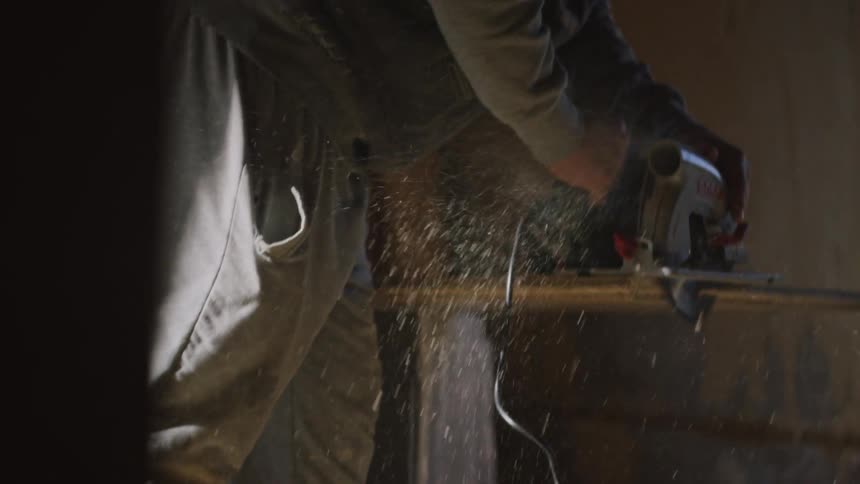 The man cuts the plywood on the construction site