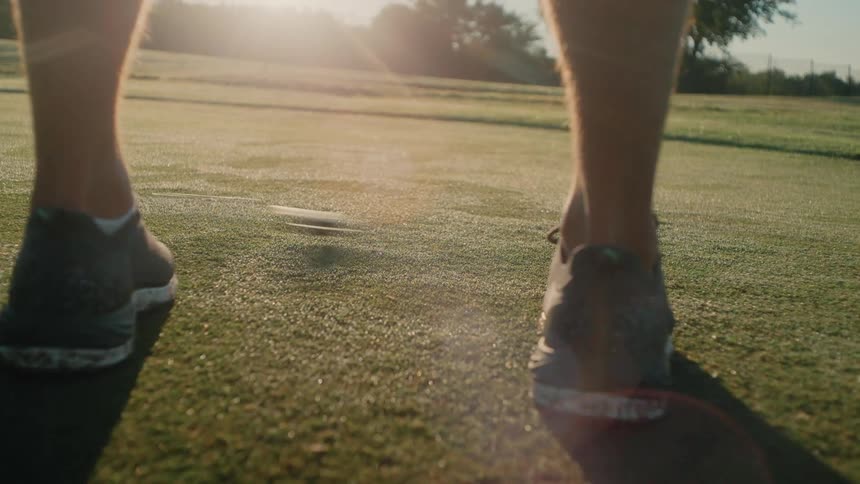 Player gently taps a golf ball with a club